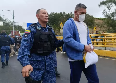 Un integrante del Instituto Nacional Penitenciario y Carcelario custodia a un hombre colombiano este miércoles, en Rumichaca (Ecuador).