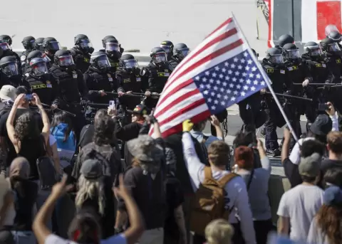 La polic�a de Los �ngeles mientras avanzan en bloque frente a un grupo de manifestantes que protesta contra las redadas de inmigraci�n.