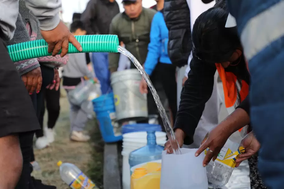 Vecinos del sur de Quito llenan recipientes de agua potable distribuida por tanqueros ante la suspensi�n del servicio tras la rotura de una tuber�a en