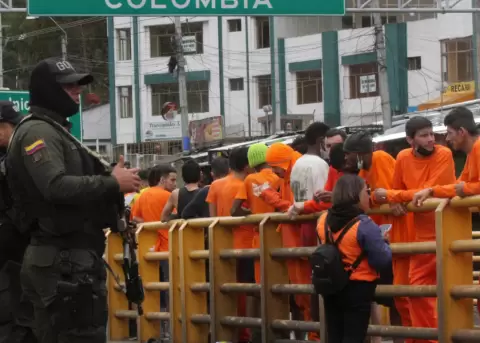 Presos colombianos deportados esperan a ser procesados por agentes de inmigraci�n tras ser deportados por el Gobierno ecuatoriano.