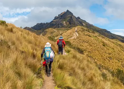 Personas en un sendero, caminando por la altitud Rucu Pichincha, en Quito.
