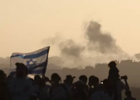 El humo se eleva desde Gaza despu�s de un ataque a�reo israel�, mientras colonos israel�es radicales se manifiestan.