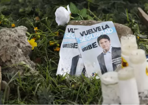Panfletos con la imagen del senador colombiano Miguel Uribe Turbay, junto a velas y flores, colocadas junto al lugar en el que fue disparado.