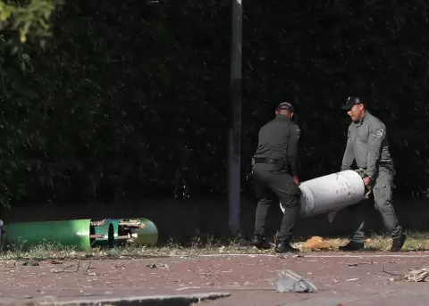 Polic�as mueven cilindros hallados tras una explosi�n en las inmediaciones de la Escuela Militar de Aviaci�n Marco Fidel Su�rez, en Cali, Colombia.