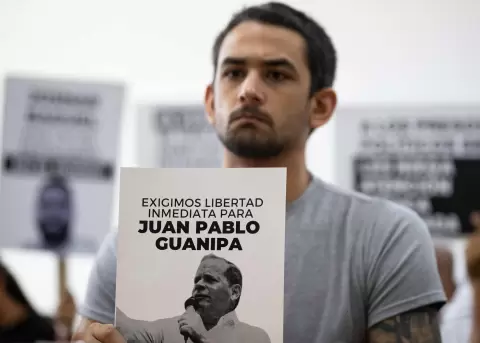 Ram�n Guanipa sostiene un cartel de su padre detenido, Pedro Guanipa, en una imagen reciente.