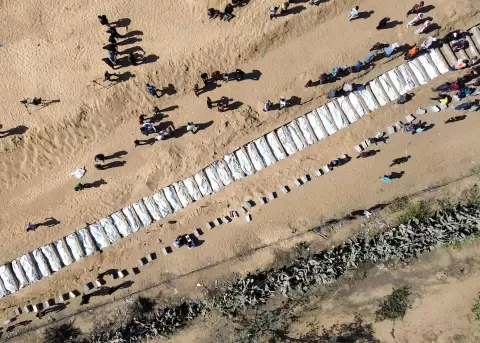 Los restos de palestinos no identificados, devueltos por Israel, se depositan en una fosa com�n durante su entierro en el centro de la Franja de Gaza.