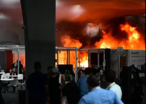 Varias personas observan c�mo las llamas del incendio devoran una parte del recinto de la COP30, la conferencia sobre cambio clim�tico de la ONU.