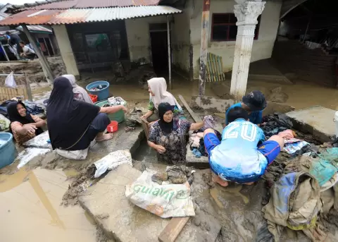 Los residentes limpian el barro de sus casas en una aldea afectada por las inundaciones en la zona de Meureudu, Pidie Jaya, Aceh, Indonesia.