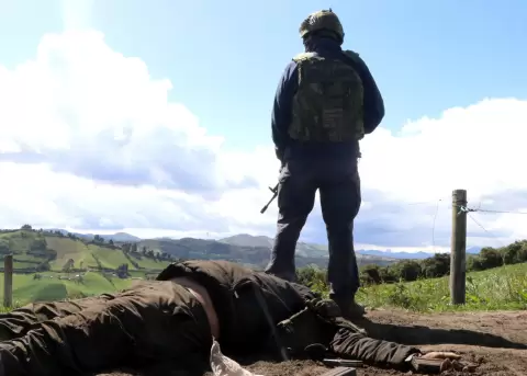 Un soldado custodia junto al cuerpo de un presunto guerrillero dado de baja durante un operativo militar en Carchi, el 16 de diciembre de 2025.