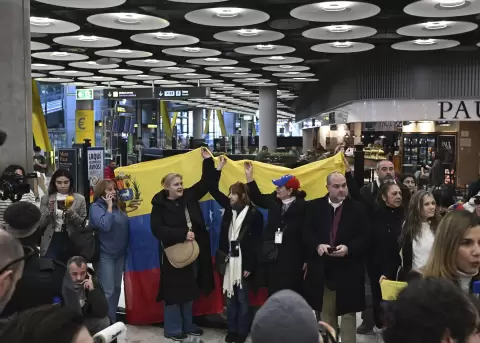 Un grupo de personas sostiene una bandera de Venezuela en el Aeropuerto Adolfo Su�rez Madrid Barajas, este 09 de enero de 2026.