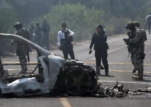 Integrantes de la polic�a de Morelia y del ej�rcito trabajan en la zona donde fue incendiado un veh�culo por integrantes del crimen organizado.
