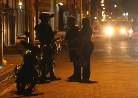 Un integrante de la Polic�a de Ecuador conversa con ciudadanos tras el toque de queda este domingo, en Guayaquil (Ecuador).