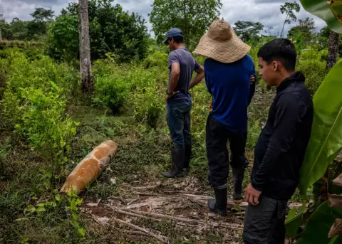 Campesinos observan una bomba hallada en territorio colombiano, cerca de la frontera con Ecuador.