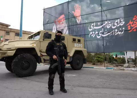 Un miembro de las fuerzas de seguridad iran�es monta guardia junto a una pancarta en honor al exl�der supremo iran� Al� Jamenei, en Teher�n, Ir�n.