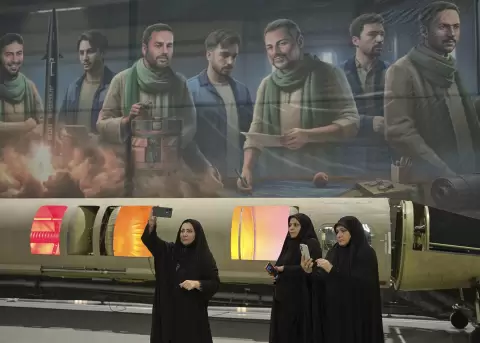 Mujeres con chador delante de un cartel de la Guardia Revolucionaria iran�.
