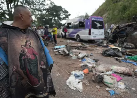 Personas observan este domingo veh�culos destruidos por un atentado ocurrido en la V�a Panamericana en Cajib�o, Colombia.