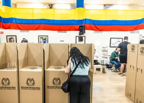 Una mujer vota en la primera vuelta de elecciones presidenciales de Colombia en Casa de Cantabria.