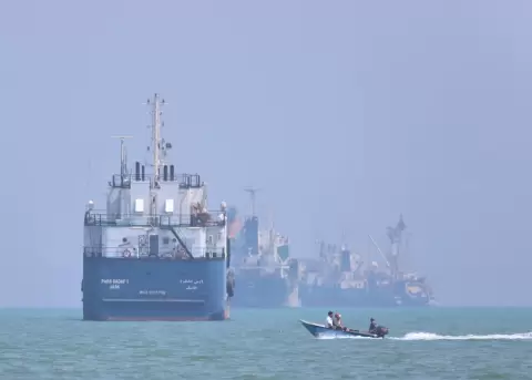 A small motorboat passes anchored vessels in the Strait of Hormuz off Bandar Abbas, Iran, on Thursday.