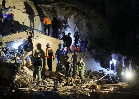 First responders attend a damaged building at Los Palos Grandes after a magnitude 7.2 earthquake struck Venezuela.