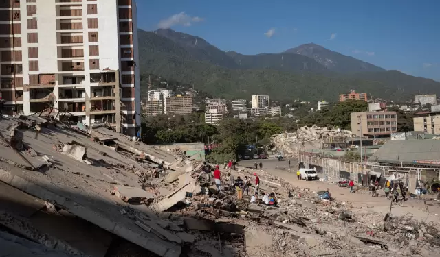 Personas observan los escombros de un edificio este lunes, en La Guaira (Venezuela).