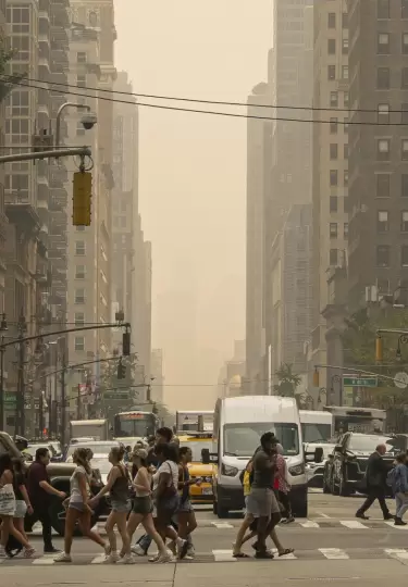 Personas caminan por una calle en Nueva York. Una densa capa de humo procedente de los incendios forestales en Canad� ha provocado una ca�da dr�stica