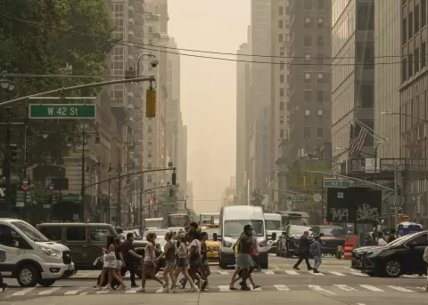 Personas caminan por una calle en Nueva York. Una densa capa de humo procedente de los incendios forestales en Canad� ha provocado una ca�da dr�stica