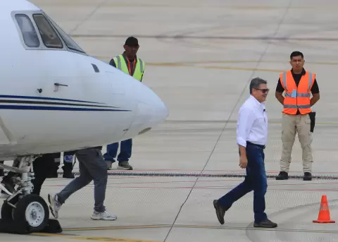 El expresidente hondure�o Juan Orlando Hern�ndez (c) (2014-2022) caminando este domingo, a su llegada al Aeropuerto Internacional de Palmerola en Coma