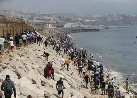 Miles de j�venes marroqu�es en la frontera entre Castillejos (Marruecos) y Ceuta para tratar de cruzar la valla que separa las dos ciudades.