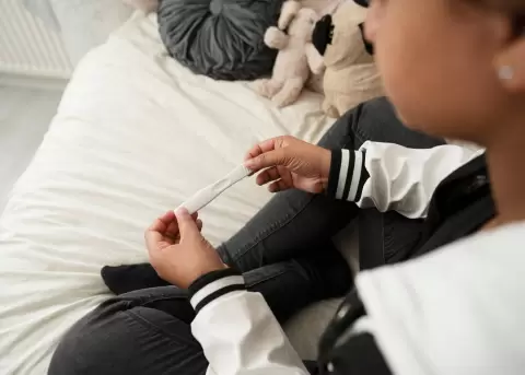 Una adolescente sostiene una prueba de embarazo.
