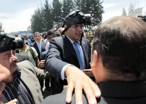 El expresidente Rafael Correa es protegido del gas lacrim�geno, el jueves 30 de septiembre de 2010, durante una protesta de efectivos policiales.